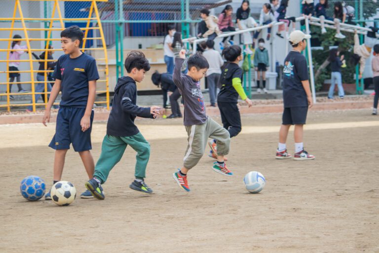Students playing soccer outside at recess
