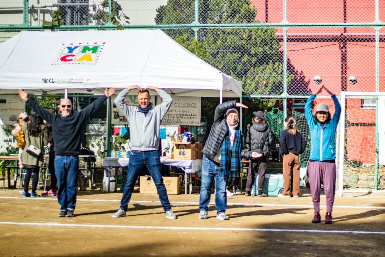 Staff and parents doing the YMCA pose